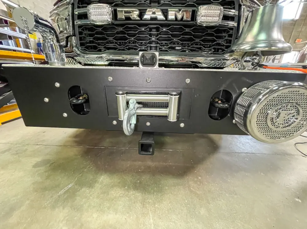 Exterior view of small fire truck showing cab, body compartments, and wheel/tire area.